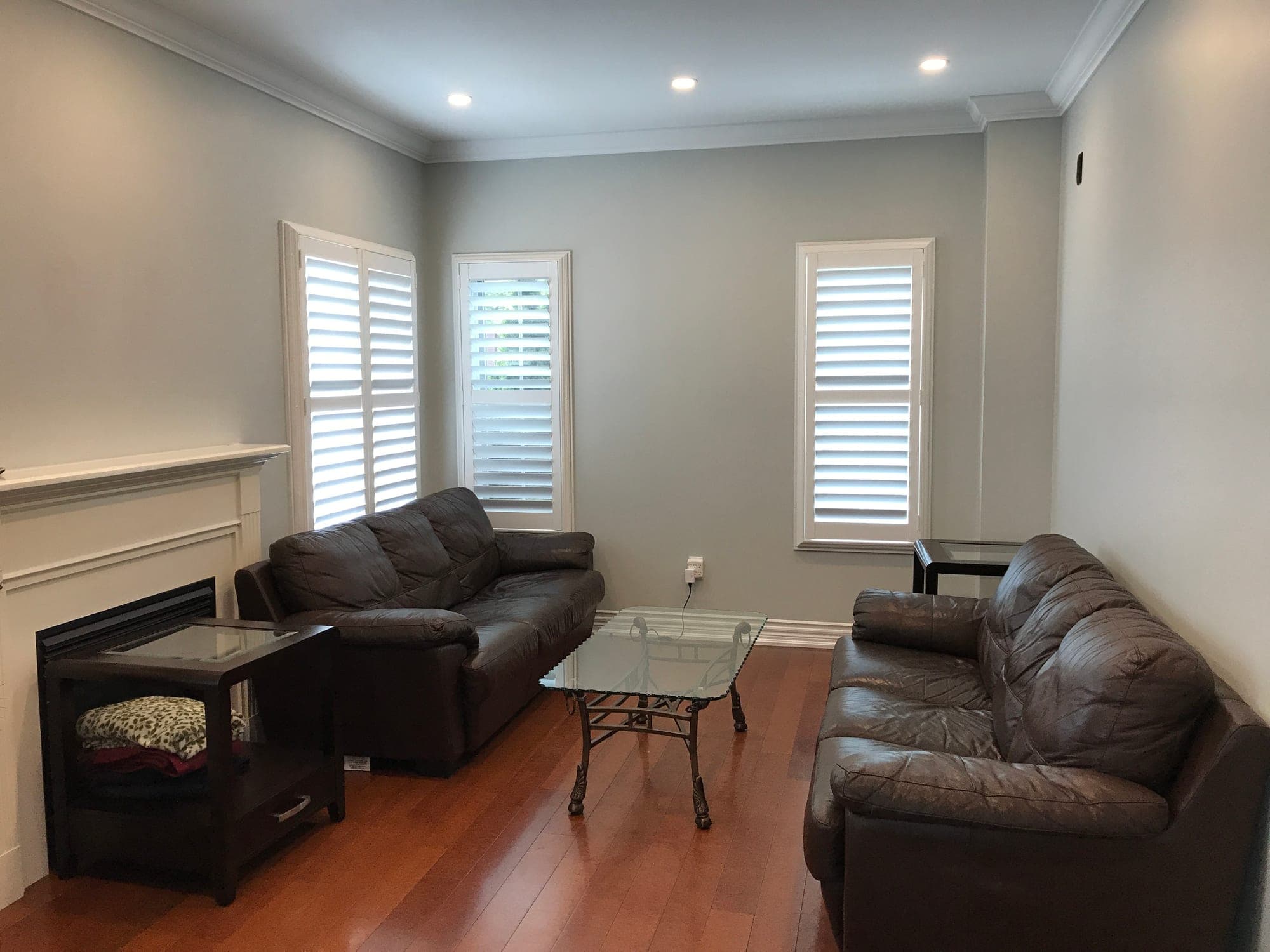 Family room with white plantation shutters and wood floors