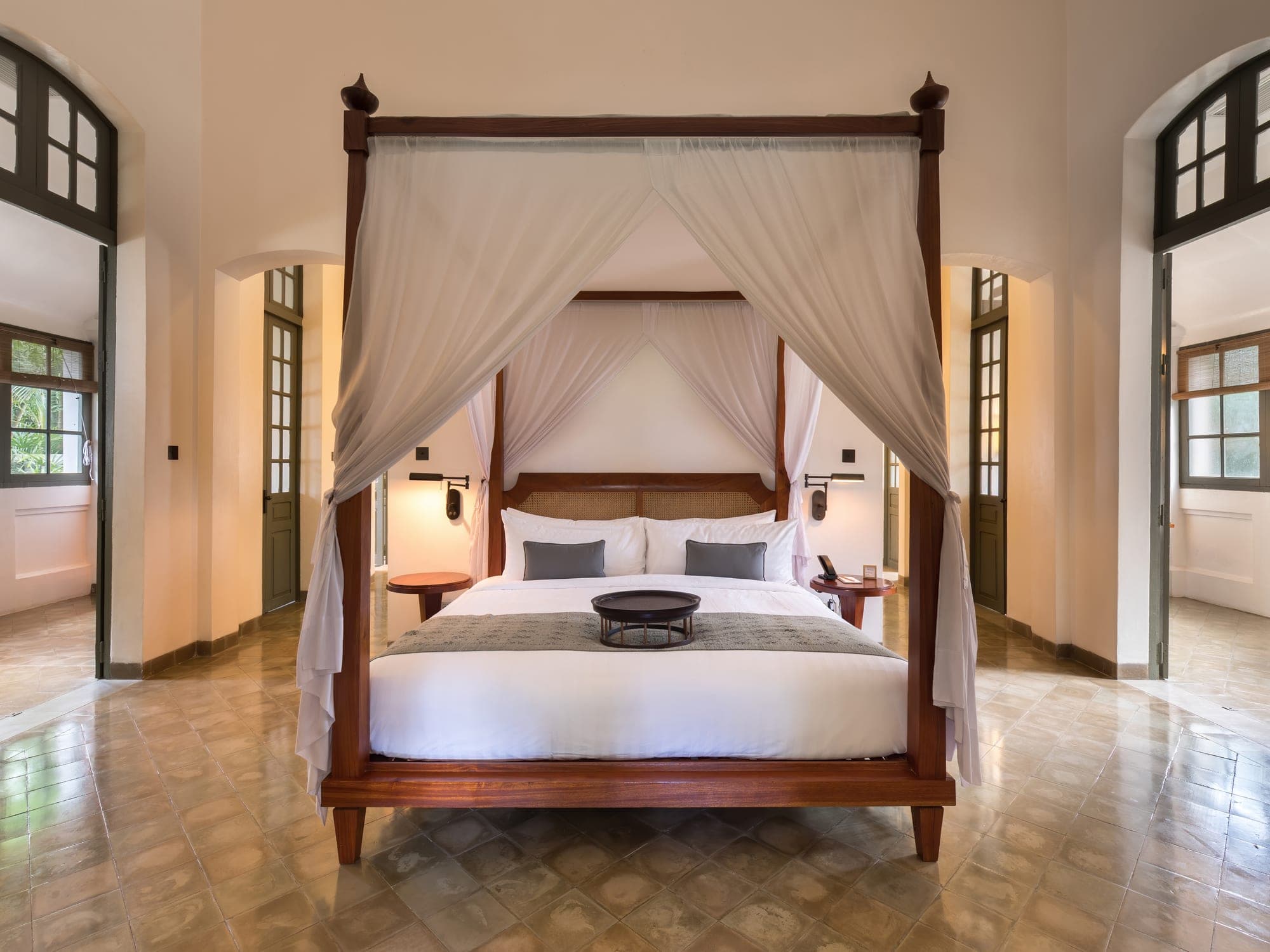Luxury resort bedroom with a canopy bed and softly draped windows